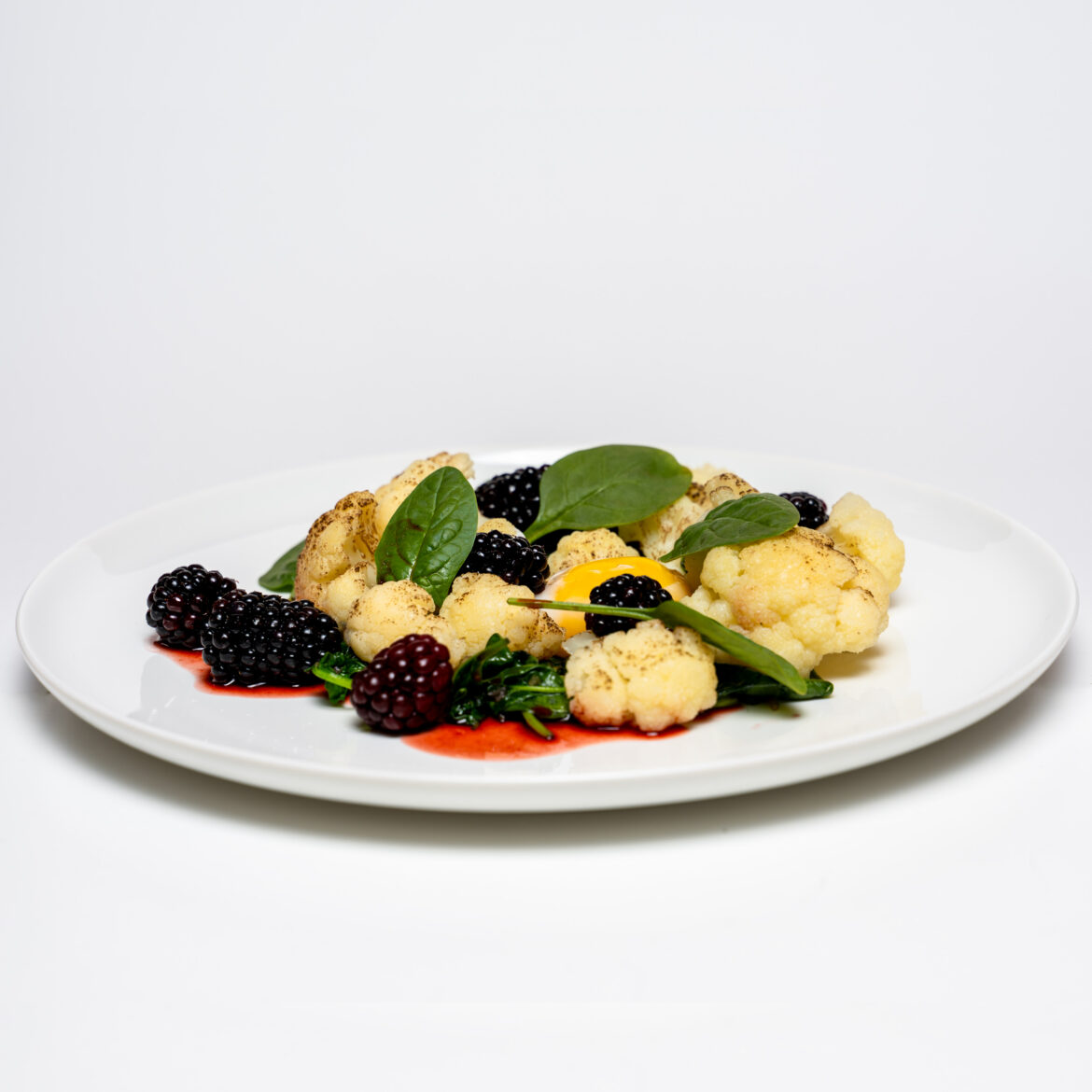 Geflämmterter Blumenkohl mit Onsen-Ei und gepickelten Brombeeren