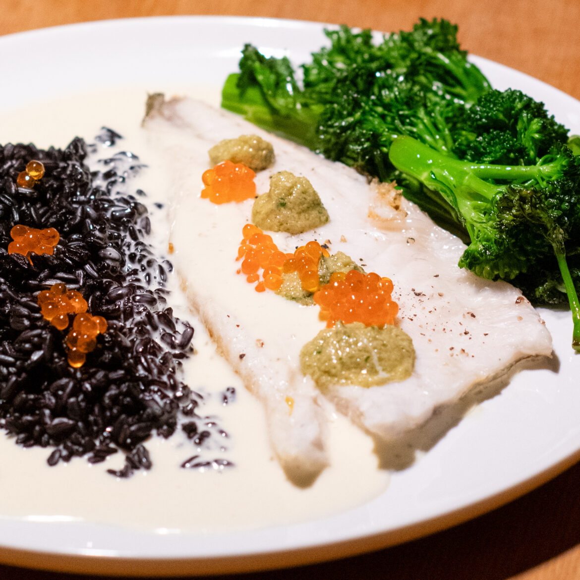 Loup De Mer mit wildem Brokkoli an schwarzem Reis